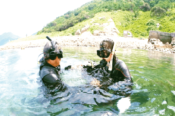 体験ダイビングを始めに、鹿島の浅い場所でインストラクターと練習をする女性の姿