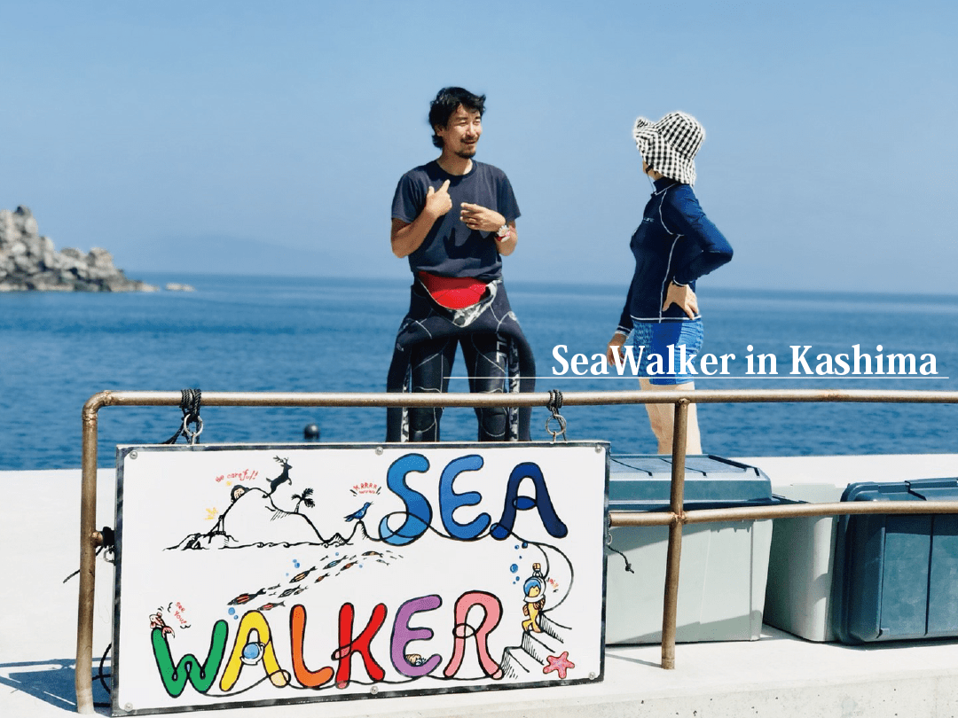 鹿島の到着桟橋でシーウォーカーのインストラクターと話をする女性。